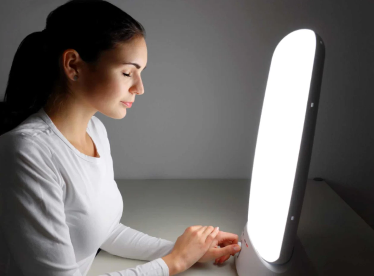 woman in front of light therapy lamp